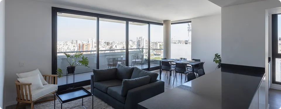 Living de un departamento de DOME Green Soho con ventanales y vista abierta a Palermo